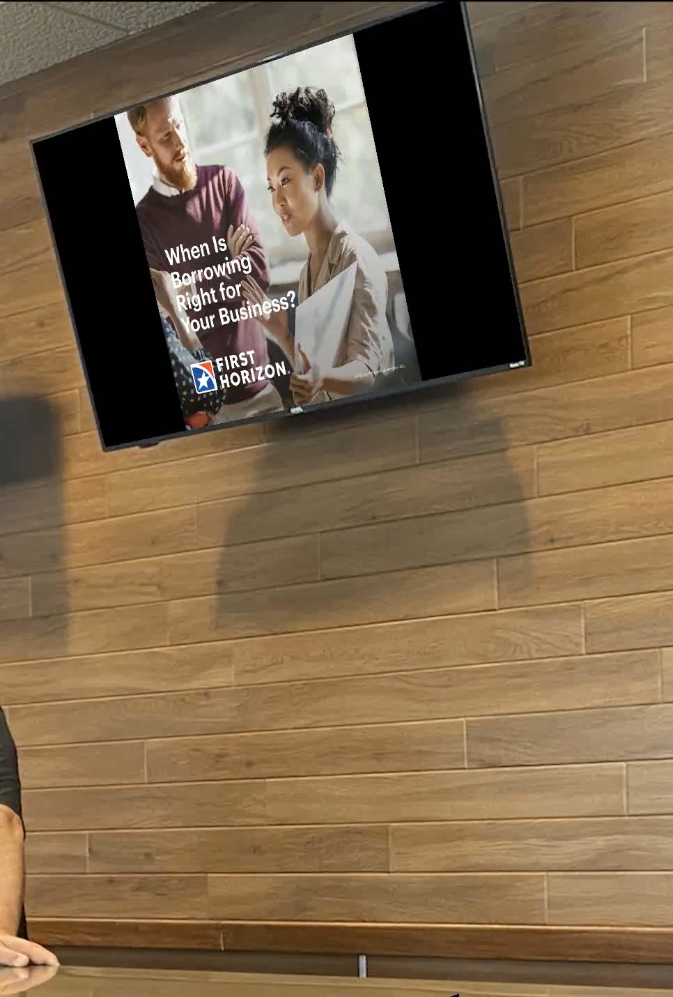 First Horizon business-banking creative on an office-building lobby screen.