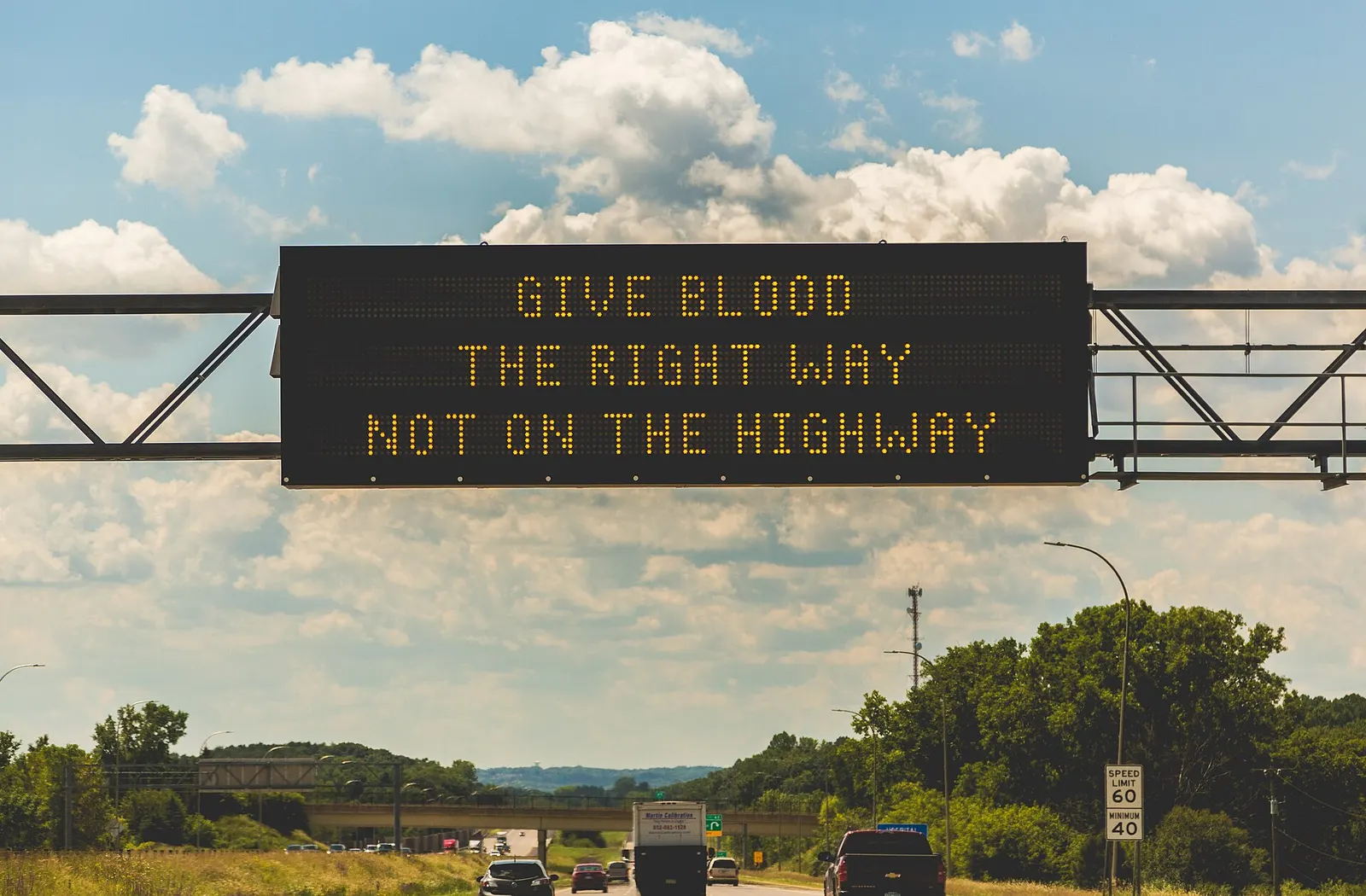 Digital sign over a Minnesota highway with traffic heading toward it.